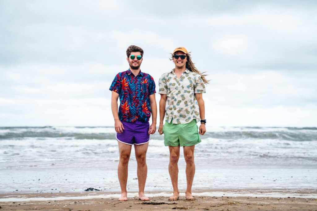 man and woman standing on beach during daytime